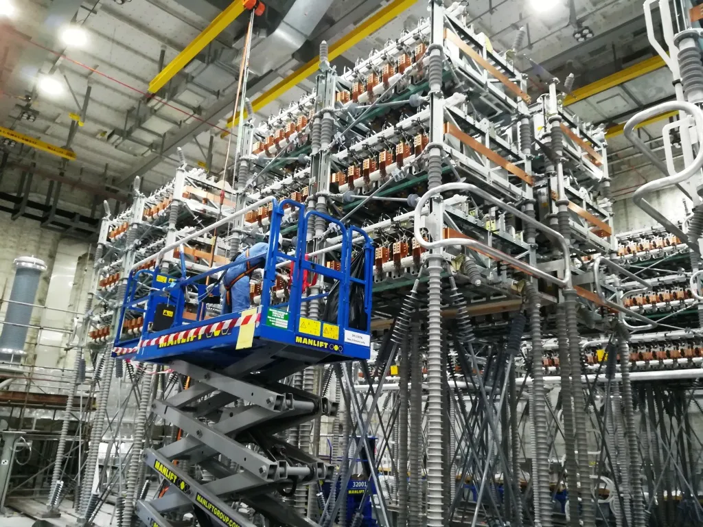 Scissor lifts positioned beneath overhead busbar runs