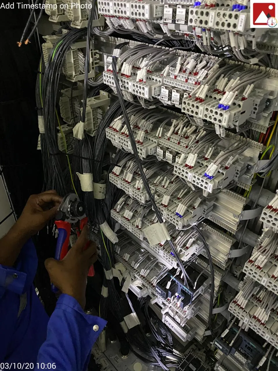 Technician terminating control wiring inside a protection panel